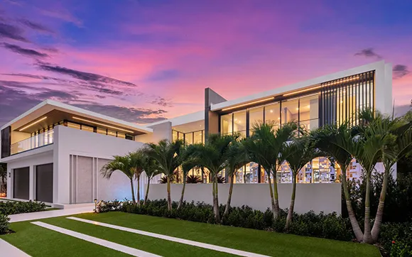 Modern luxury home exterior at sunset, showcasing new construction properties in Coral Gables, FL